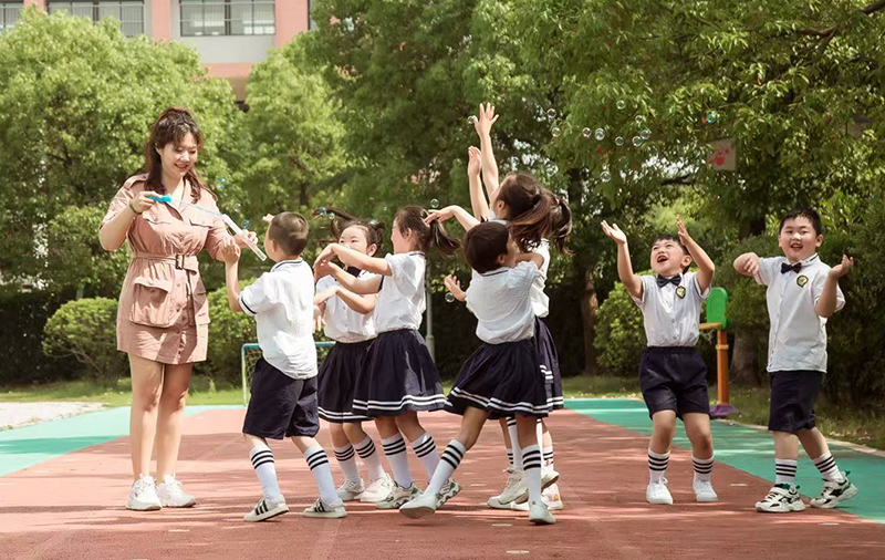 幼儿园长期开展幼儿亲近自然的课程研究，图为老师带领孩子们探究泡泡的产生。